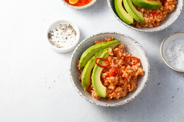 Spicy rice with avocado and chili sauce