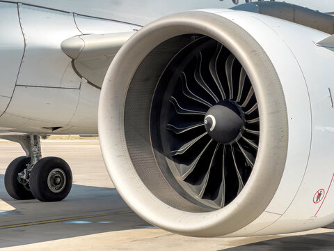 Jet engine under the wing of a commercial airliner standing in a parking lot