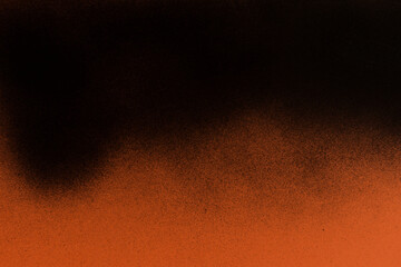 Black spray paint on orange paper background