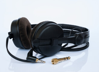 Professional DJ black headphones with velor ear pads and gold-plated 6.3mm jack adapter on a white...