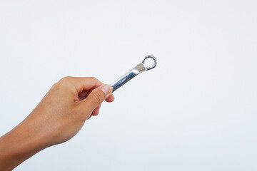 Man's hand is holding a ring spanner to tighten something.