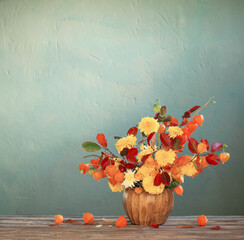 beautiful autumnal  bouquet on wooden table on dark wall