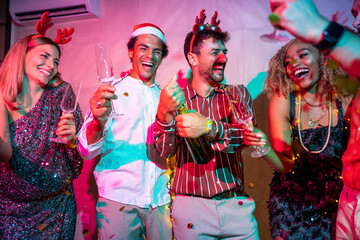 Friends opening bottle of champagne at New Year party midnight countdown