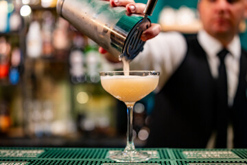 man hand bartender making cocktail in glass on the bar counter