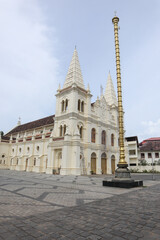 A Low angle picture of the Iconic 'Santa Cruz Cathedral Basilica' Church with the Brass Pillar or Manasthamba in front in Kochi city of Kerala state, India.