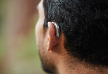 Closeup of hearing aid, ear and man with disability from the back for medical support, listening...