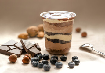Chocolate Trifle in a cup with pieces of chocolate, blueberries, hazelnuts