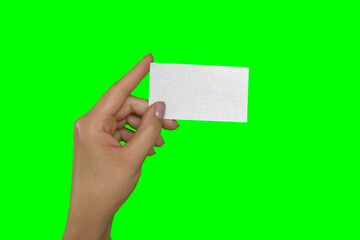 Female Hand Holding White Business Card Isolated On Green Background. Close Up. Visiting Card Template, Mock Up. Chroma Key Screen. Woman's Hand with Plastic Gift Card MockUp. Advertisement gesture.