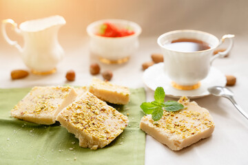 tea, milk, cakes, chocolate pieces, halva on the table