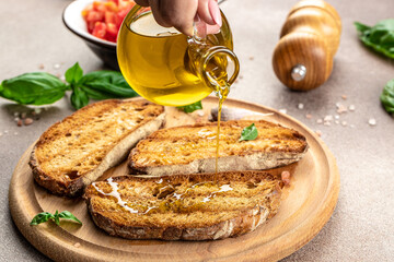 Pouring oil on tasty bruschetta, Toasted bread with garlic, Restaurant menu, dieting, cookbook recipe top view