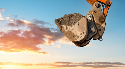 Excavator rising bucket against sky background © Iryna