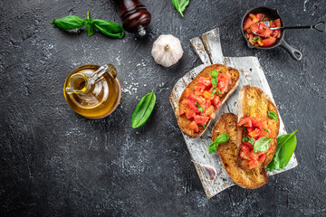 Italian tomato bruschetta with basil, garlic and olive oil on grilled or toasted crusty ciabatta bread, banner, menu, recipe place for text, top view