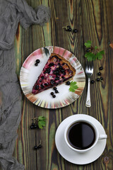 Baked pie with season berries and cup of coffee on wooden background