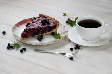 Baked pie with season berries and cup of coffee on wooden background
