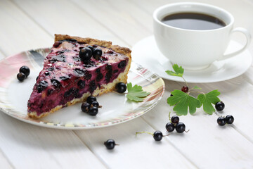 Baked pie with season berries and cup of coffee on wooden background
