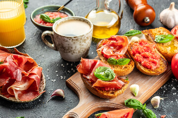 Spanish breakfast with toasted bread with oil, jamon and tomato, coffee and orange juice. place for text, top view