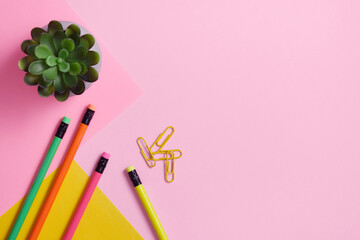 Pencils and paper clips on a roh and yellow background. Stationery background.