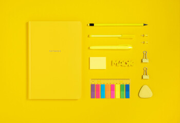 Yellow school and office stationery on yellow background. Flatlay.