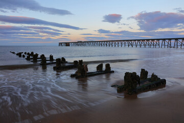 View of a old derelict industrial pier with groins in the foreground. Hartlepool, County Durham, England, UK. - obrazy, fototapety, plakaty
