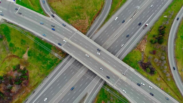 Aerial view massive highway intersection, stack interchange with elevated road junction overpass at early morning in American. This five-level freeway interchange carry heavy traffic, panorama.