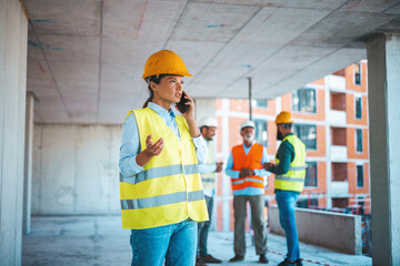 Shot of a young engineer using a smartphone in an industrial place of work. Architect is using...