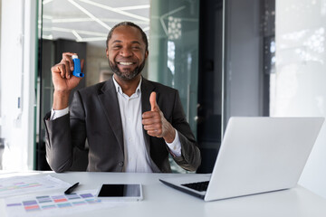 Satisfied patient after treatment with asthma inhaler, man inside office at workplace smiling and...