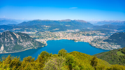Fototapeta na wymiar Lugano Lake, Italian: Lago di Lugano, and Lugano city. Lookout from Balcony of Italy on Mount Sighignola. Italy and Switzerland