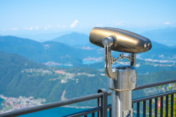 Paid tourist metal binocular above Lugano Lake, Italy and Switzerland