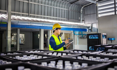 In a drink water factory, a tablet computer is being used by a skilled engineer or quality...