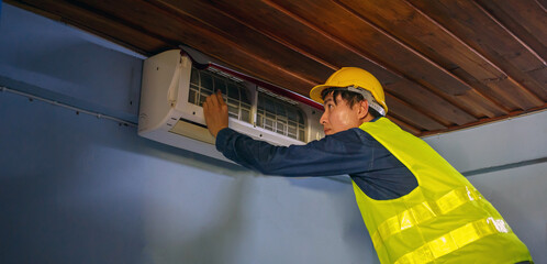 The skilled air conditioner technician is working on the repair and removal of an air conditioning...
