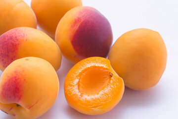 Fresh, ripe apricots on a clean white background, showcasing their natural vibrant color and juicy appeal.