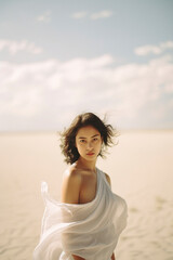 A young woman in the desert in a simple white dress and the wind blows her clothes. The concept of mental health.