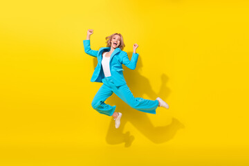 Full size photo of overjoyed good mood girl dressed blue jacket trousers jumping raising fists win...