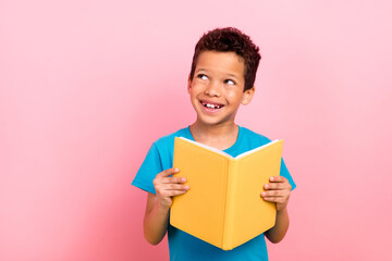 Photo of dreamy thoughtful small boy wear blue t-shirt enjoying fairytales looking empty space isolated pink color background