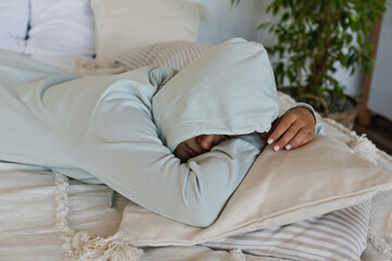 Offended tired child lies on the bed with a hood on his head at home. Mental health, psychological problem