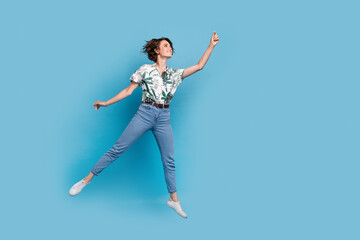 Full length photo of carefree dreamy lady wear print shirt jumping high holding empty space...