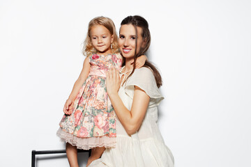 Studio portrait of young mother with her daughter isolated on white background.