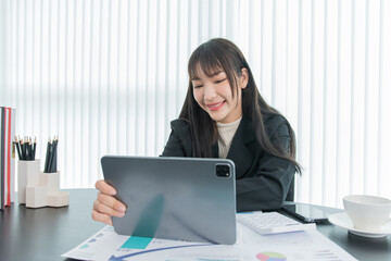 business woman working on the tablet ,discussing customer and checking business analytic document report working place in office.