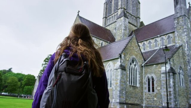 Low Dolly Shot Of Woman Approaching 19th Century Cathedral