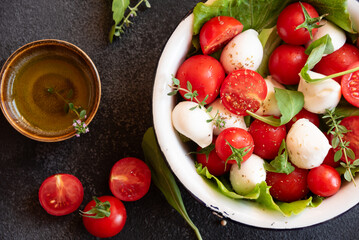 Caprese salad with mozzarella cheese and tomatoes of Italian cuisine