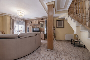 A living room with some wooden furniture, cream-colored walls