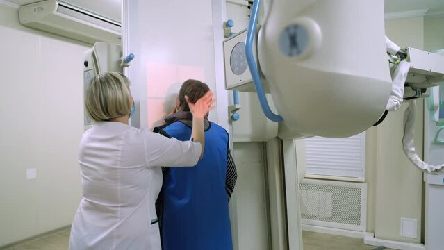 The doctor radiologist prepares the patient for an x-ray.