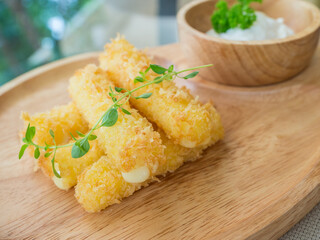 fried cheese stick on a wooden pate