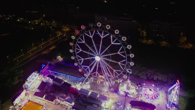 Aerial view of Vibrant amusement park at night with illuminated cityscape in Turia Park, Mestalla, Valencia, Spain