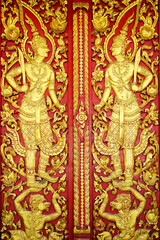 Fototapeta premium Thai paintings on the temple gates are bas-reliefs depicting deities with Thai art patterns.