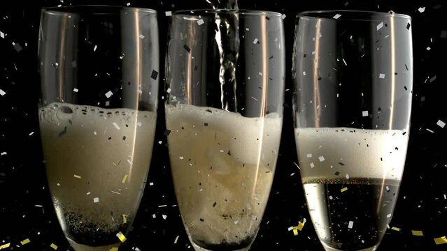 Animation of champagne pouring in glasses and confetti exploding over black background