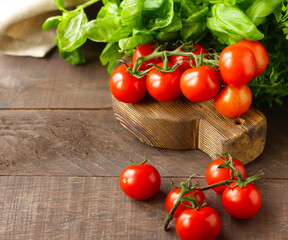 fresh organic tomatoes and basil on wooden background