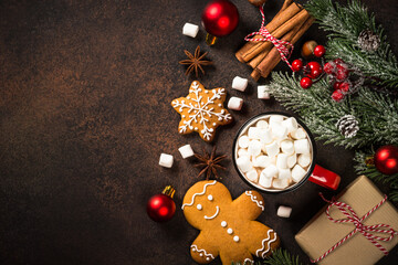 Hot chocolate and gingerbread cookies with christmas decorations at dark stone table. Top view with copy space.