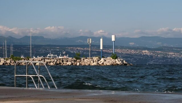 Continuously changing sea or ocean surface in the Kvarner Bay with out of focus Rijeka, Croatia in the background. Beautiful, fresh, deep blue wavy water. Abstract and minimalistic 4K slow motion.