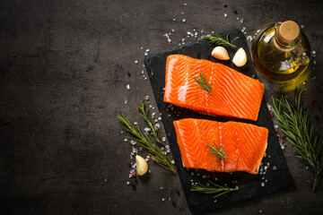 Fresh fish. Raw salmon fillet at cutting board with ingredients for cooking. Top view with copy...